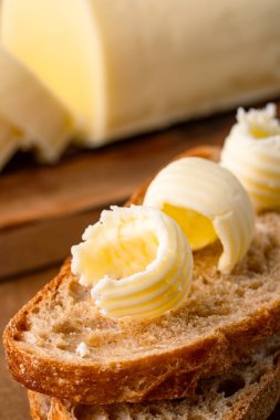 Yemeklere lezzet katan tereyağı ve ahşap arka planda kahvaltı içindir.