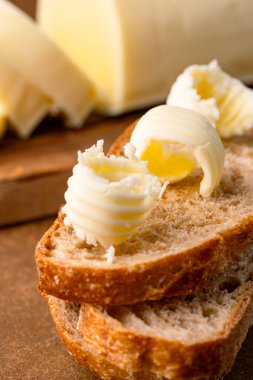 Yemeklere lezzet katan tereyağı ve ahşap arka planda kahvaltı içindir.