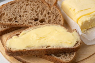 Yemeklere lezzet katan tereyağı ve ahşap arka planda kahvaltı içindir.