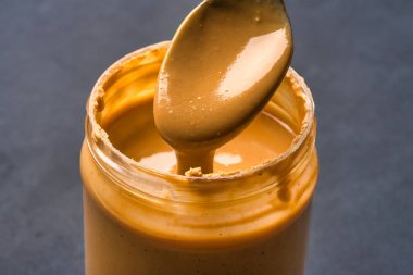 Siyah arka planda lezzetli ve sağlıklı fıstık ezmesi.