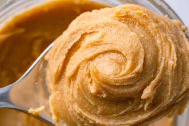 Beyaz arka planda lezzetli ve sağlıklı fıstık ezmesi.