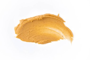 Beyaz arka planda lezzetli ve sağlıklı fıstık ezmesi.