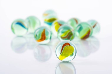 Beyaz arkaplanda renkli cam bilyeler topu