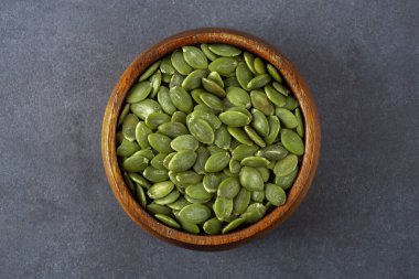 Ahşap arka planda lezzetli kabak tohumları