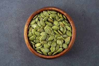 Ahşap arka planda lezzetli kabak tohumları