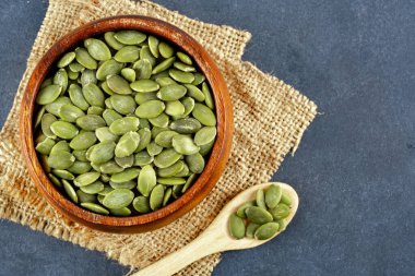 Ahşap arka planda lezzetli kabak tohumları