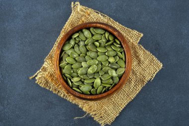 Ahşap arka planda lezzetli kabak tohumları