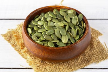 Ahşap arka planda lezzetli kabak tohumları