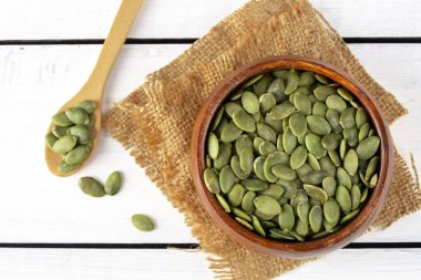 Ahşap arka planda lezzetli kabak tohumları