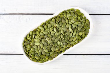 Ahşap arka planda lezzetli kabak tohumları