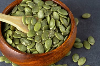 Ahşap arka planda lezzetli kabak tohumları