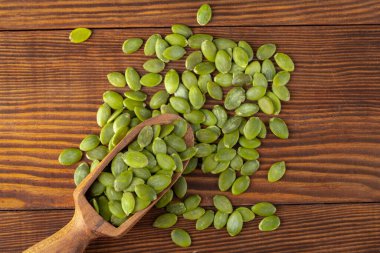 Ahşap arka planda lezzetli kabak tohumları