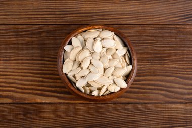 Ahşap arka planda lezzetli kabak tohumları