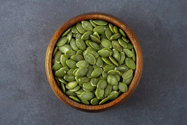 Ahşap arka planda lezzetli kabak tohumları