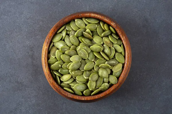 Ahşap arka planda lezzetli kabak tohumları