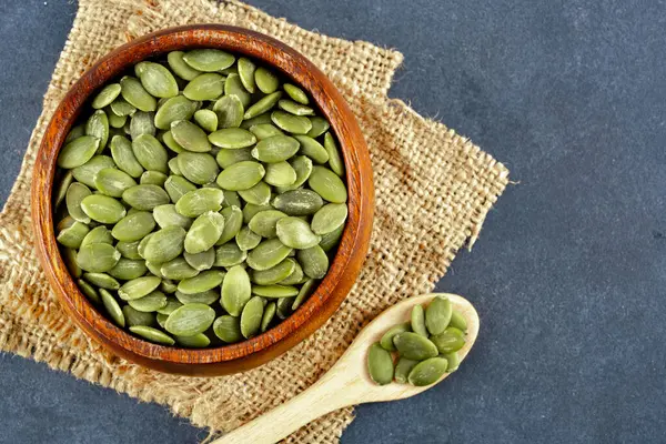 Ahşap arka planda lezzetli kabak tohumları