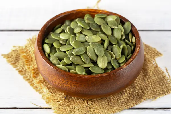 Ahşap arka planda lezzetli kabak tohumları