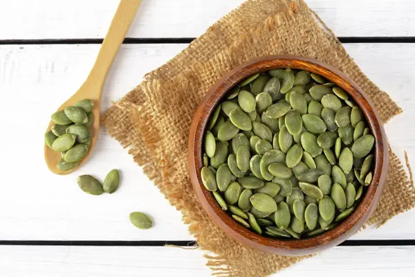 Ahşap arka planda lezzetli kabak tohumları