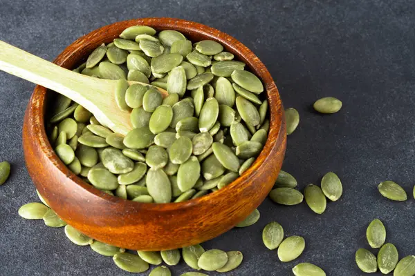 Ahşap arka planda lezzetli kabak tohumları