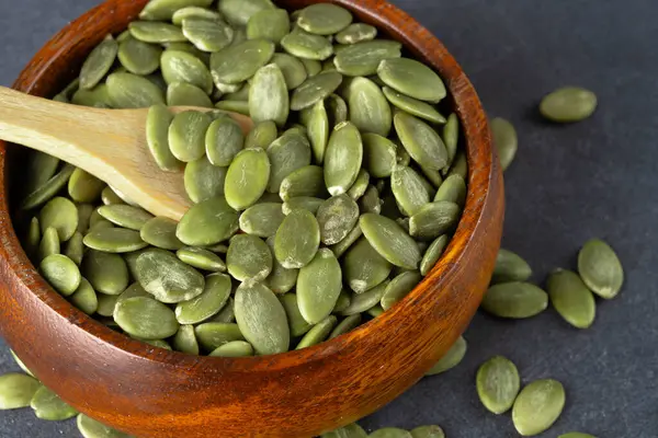 Ahşap arka planda lezzetli kabak tohumları