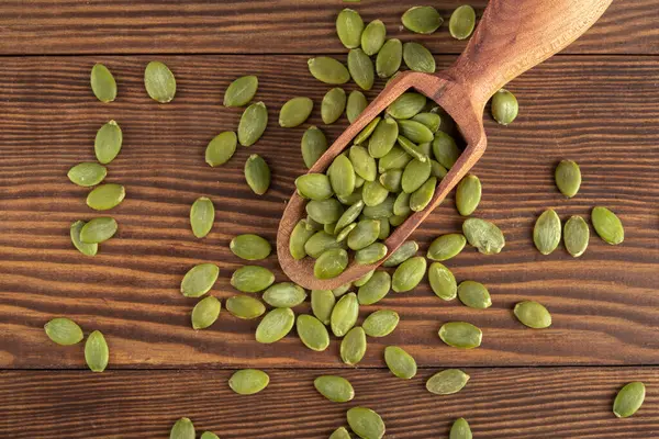 Ahşap arka planda lezzetli kabak tohumları