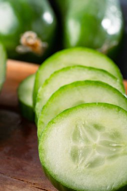 Taş masada doğranmış taze salatalık dilimleri.