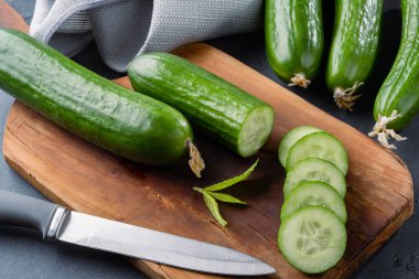 Taş masada doğranmış taze salatalık dilimleri.