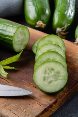 Taş masada doğranmış taze salatalık dilimleri.