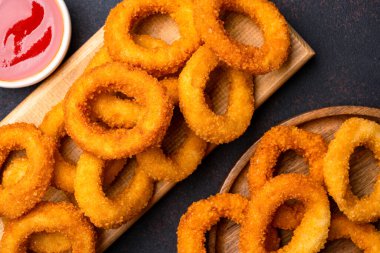  Siyah arkaplanda kızarmış soğan halkaları