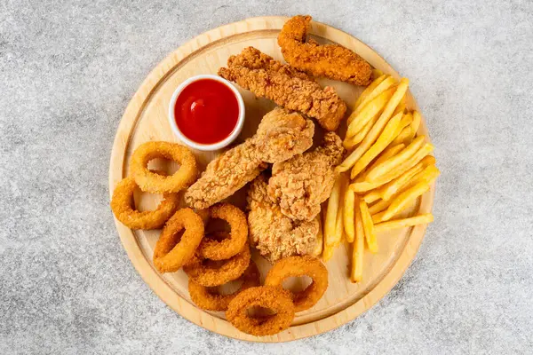 Tavuk filetosu, kanat, soğan halkası ve patates kızartması.