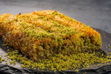 Lezzetli Türk fıstıklı kadayif tatlısı. Siyah arkaplanda Burma kadayif