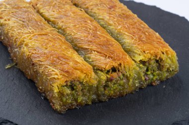 Lezzetli Türk fıstıklı kadayif tatlısı. Siyah arkaplanda Burma kadayif