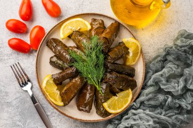 Lezzetli Türk yemekleri, doldurulmuş üzüm yaprakları, taş bir masanın üzerinde.