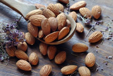 Tahta bir masada, tahta bir kaşıkta badem. Badem ve kekik.