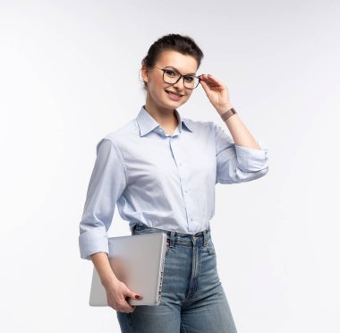 Beyaz arka planda dizüstü bilgisayar taşıyan gülümseyen bir iş kadını portresi