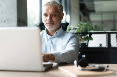 Olgun 40 'lar odaklı iş adamı, dizüstü bilgisayarla çalışan yönetici ofiste veri tabanında araştırma yapan. Başarılı iş adamı, lider, CEO müdürü, borsa şifreli para ticareti.