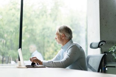Olgun 40 'lar odaklı iş adamı, dizüstü bilgisayarla çalışan yönetici ofiste veri tabanında araştırma yapan. Başarılı iş adamı, lider, CEO müdürü, borsa şifreli para ticareti.