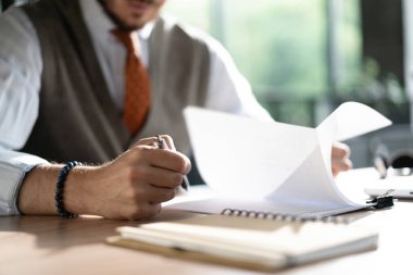 İş adamı ellerinin kalem tutması kağıt yığınıyla çalışmak, bilgi aramak, iş raporları ve modern ofiste tamamlanmamış yığınla belge.