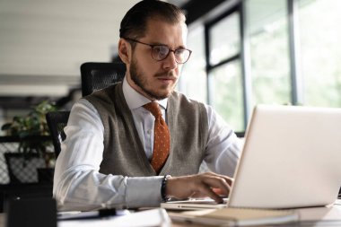 Modern Ofis İşadamı Bilgisayar üzerinde çalışıyor. Başarılı orta yaşlı bilişim yazılım mühendisinin portresi masasında dizüstü bilgisayarda çalışıyor.