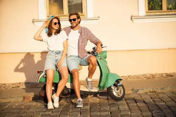 Aşık bir çift gün batımında bir motosikletin yanında duruyor. Yakışıklı adam ve genç seksi kadın seyahati. Seyahat, romantizm, eğlence. Macera ve tatil kavramı.