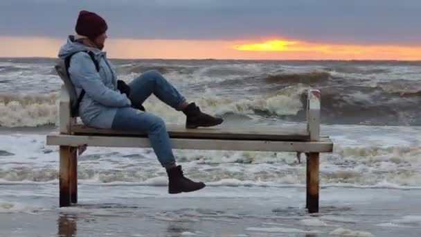 Ensom Pige Sidder Bænk Ved Havet Vinterstorm Høj Kvalitet Fullhd – Stock-video