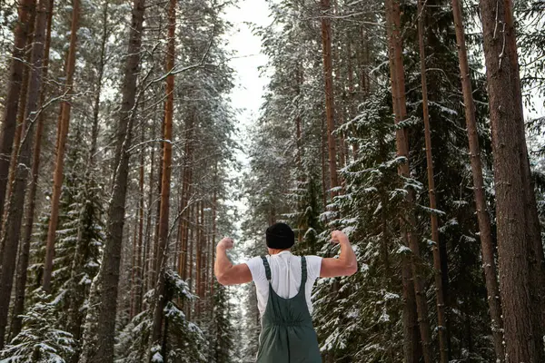 Kış Ormanlarında Kar Taneleriyle Çevrili Atletik Görünümlü Genç Bir Adam — Stok fotoğraf
