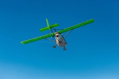 Kış aylarında mavi gökyüzünde uçan tek pervaneli bir uçak.