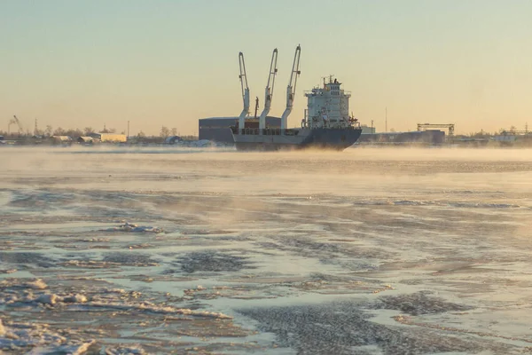 Cargo ship, ice classed bulk carrier in the ice and fog of a freezing river. High quality photo