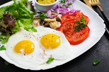 Ketojenik gıda. Yağda yumurta, mantar ve dilimlenmiş domates. Keto, paleo kahvaltı..