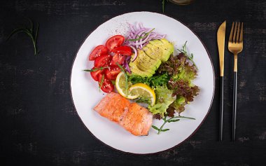 Ketogenik diyet kahvaltısı. Fırında somon salatası, yeşillik, domates, kırmızı soğan ve avokado. Keto, paleo yemeği. Üst görünüm, genel görünüm