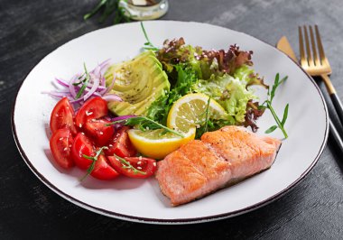 Ketogenik diyet kahvaltısı. Fırında somon salatası, yeşillik, domates, kırmızı soğan ve avokado. Keto, öğle yemeği..