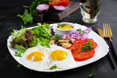 Ketojenik gıda. Yağda yumurta, mantar ve dilimlenmiş domates. Keto, paleo kahvaltı..