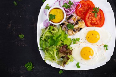 Ketojenik gıda. Yağda yumurta, mantar ve dilimlenmiş domates. Keto, paleo kahvaltısı. Üst görünüm, genel görünüm, kopyalama alanı