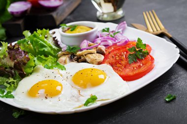 Ketojenik gıda. Yağda yumurta, mantar ve dilimlenmiş domates. Keto, paleo kahvaltı..